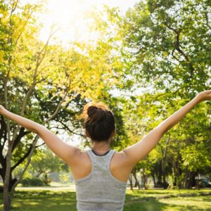 Mujer joven realizando estiramientos antes de hacer ejercicio como parte de un estilo de vida saludable